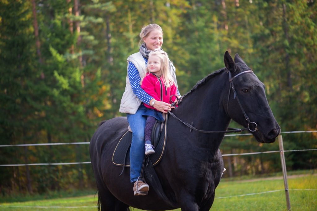 Mutter und Tochter auf einem Pferd